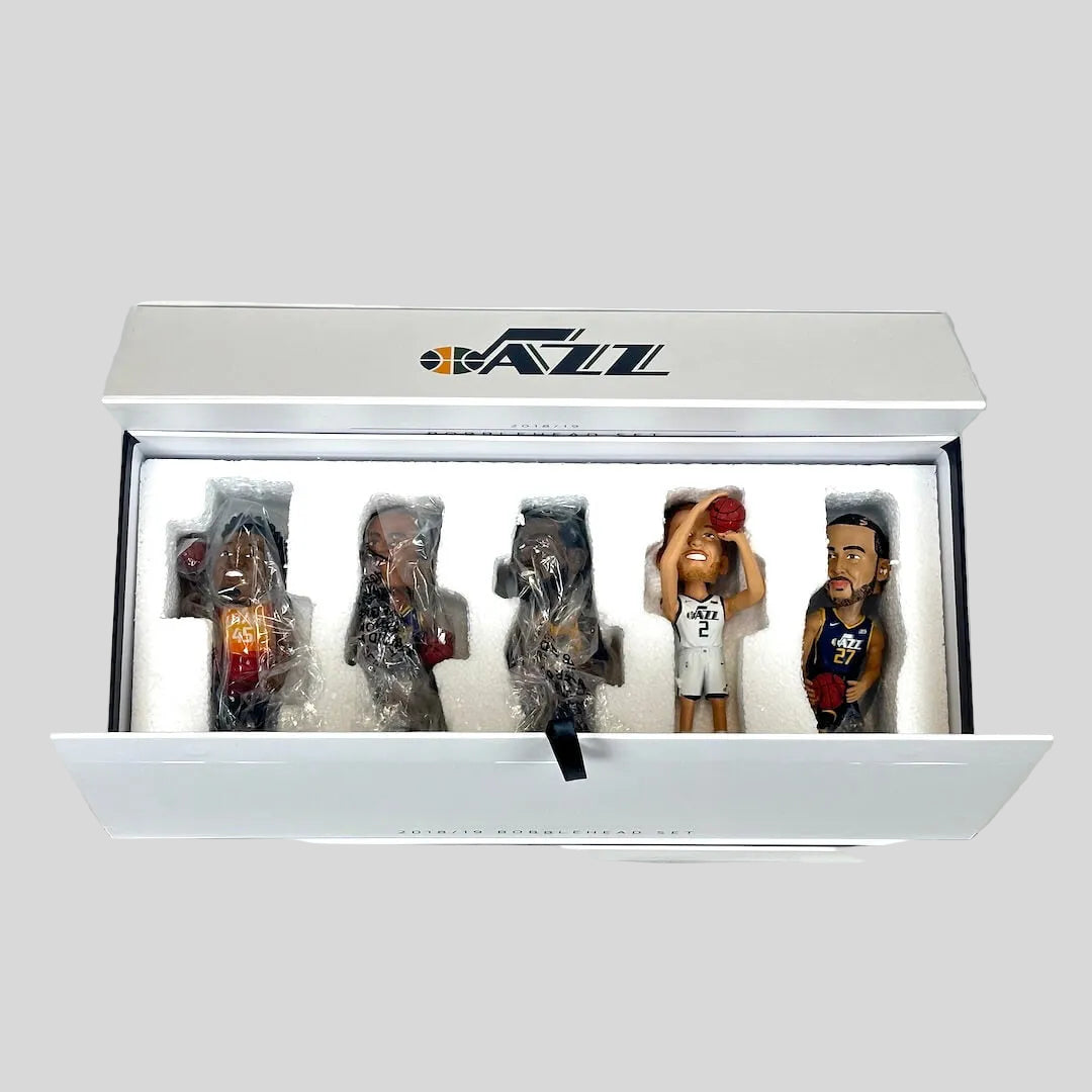 Set of five bobblehead figures in a display case with a white background