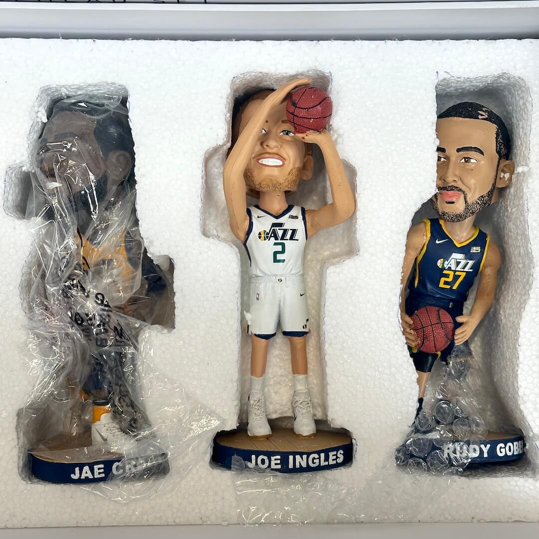 Three basketball bobbleheads in packaging, including Jae Crowder, Joe Ingles, and Rudy Gobert.