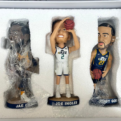 Three basketball bobbleheads in packaging, including Jae Crowder, Joe Ingles, and Rudy Gobert.