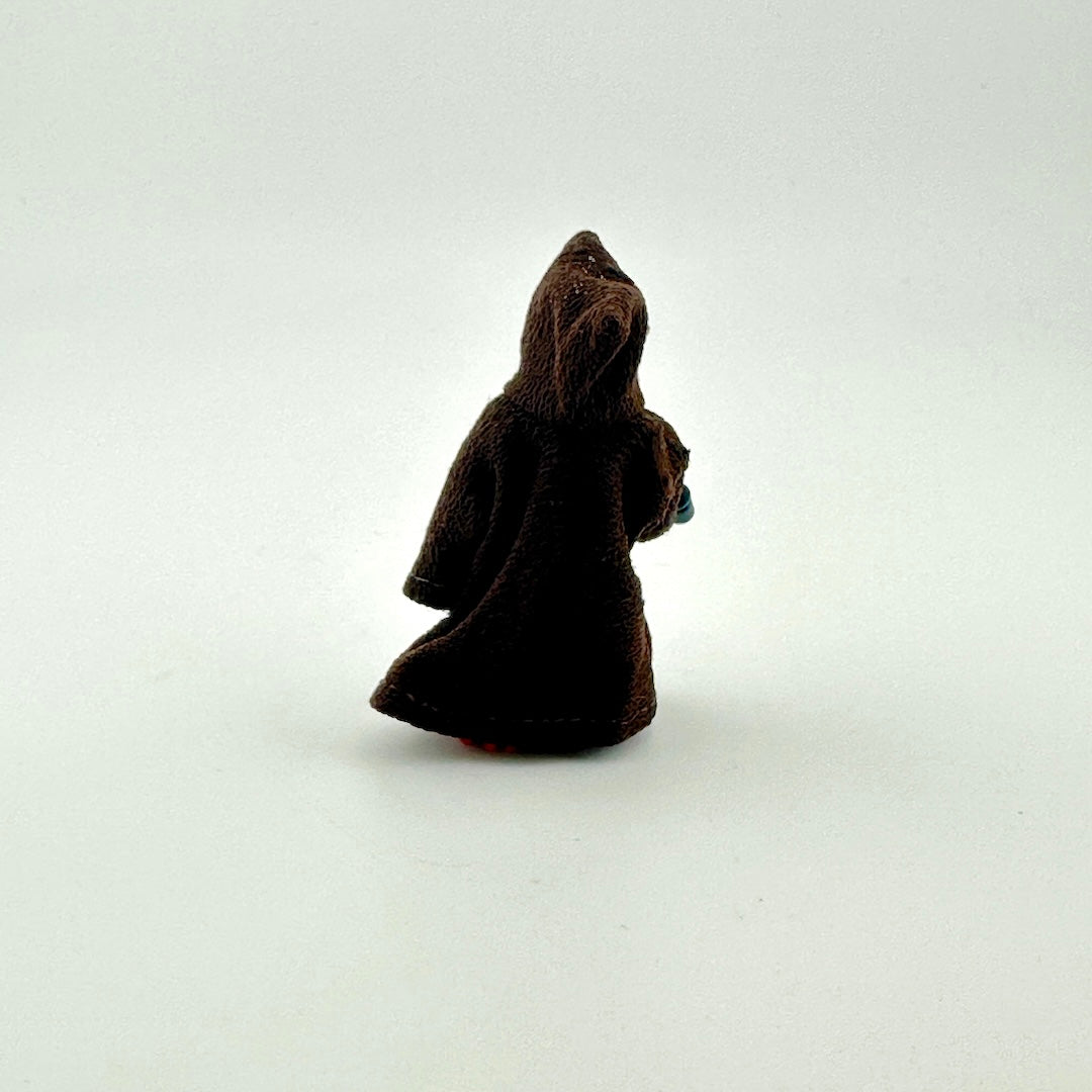Small brown figure wearing a hood on a white background