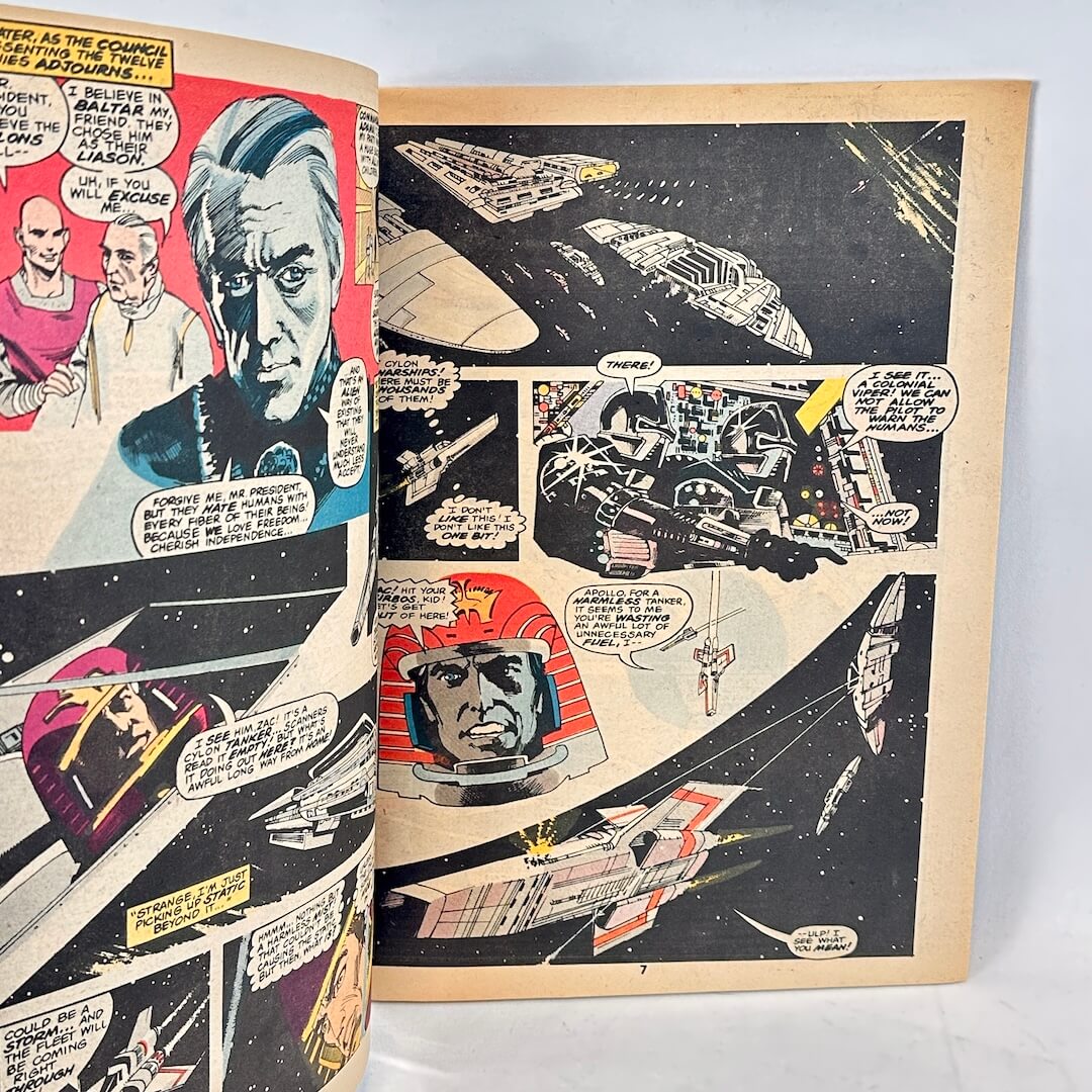 An open vintage comic book showing two printed pages with illustrated sci-fi space scenes, spacecraft, and comic panels.