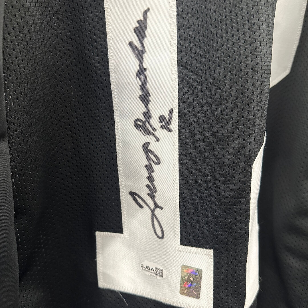 Close-up of signature in number '1' on back of the jersey, authentication stickers below signature. 