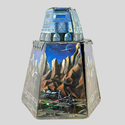 Vintage playset folded into rough hexagonal shape with smaller portion on top. Decorated with sci-fi elements. 