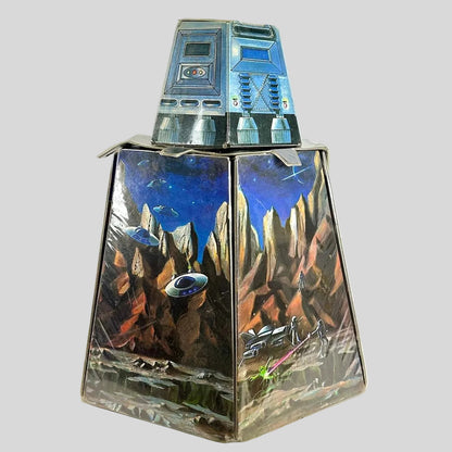 Vintage playset folded into rough cylinder shape with smaller portion on top. Decorated with sci-fi elements. 