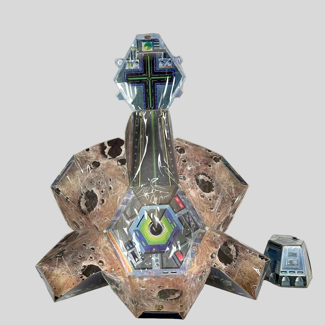 Unfolded playset to show planetoid decoration with landing pad in center. 