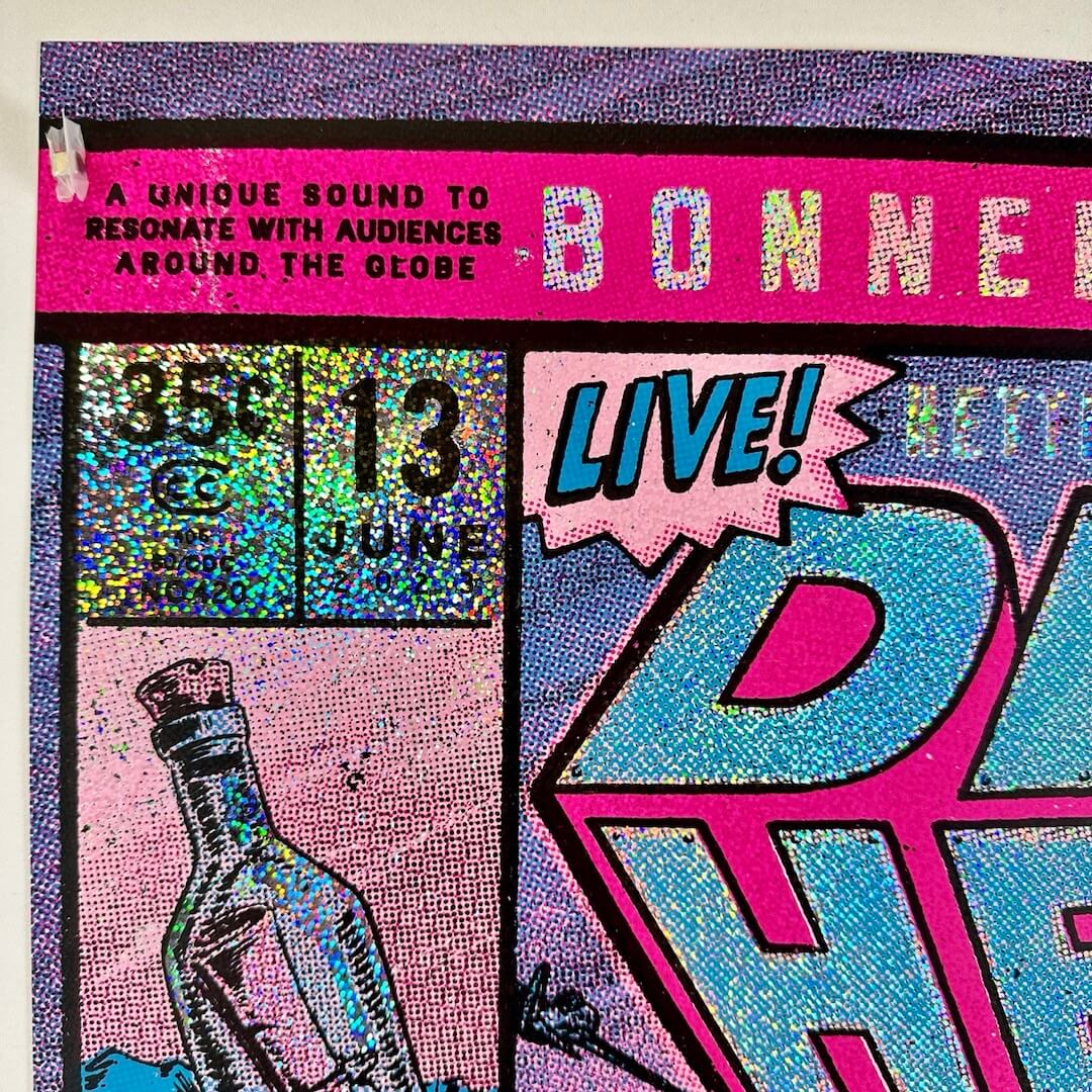 Top left corner of poster showing crisp corner, no damage to edges, glitter foil detail, event info partially visible. 