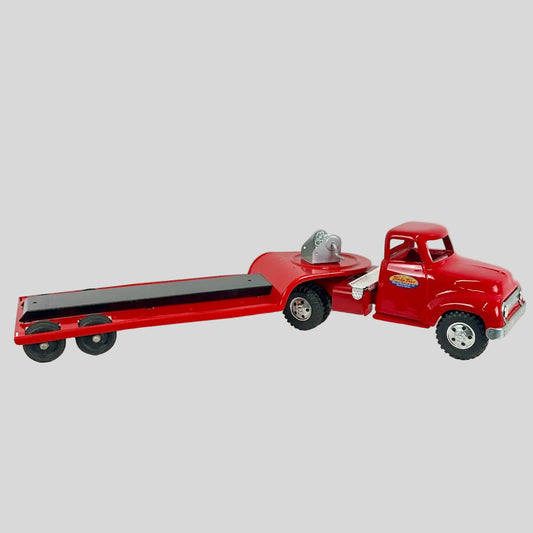Red toy truck with a flatbed trailer on a white background