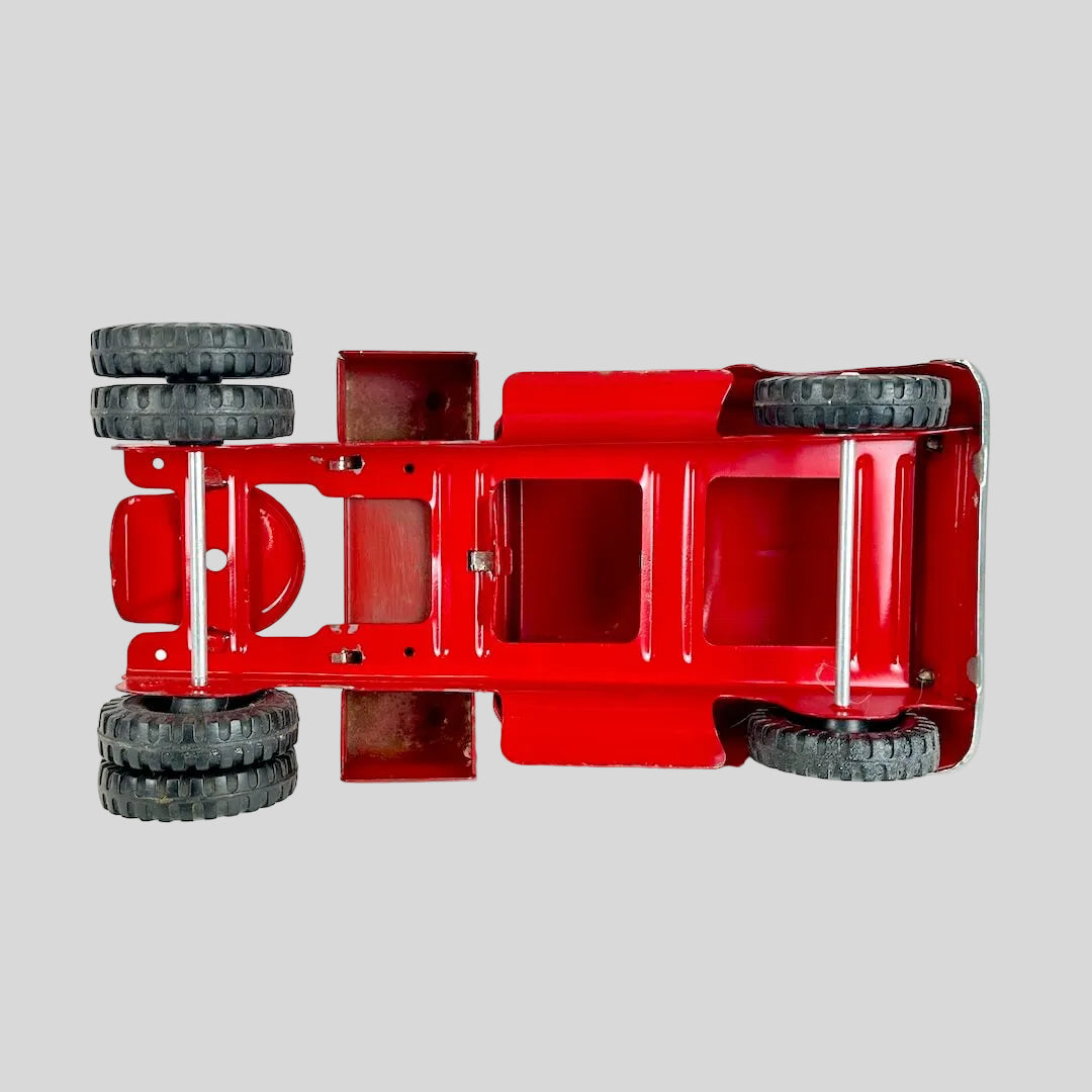 Red toy truck chassis with wheels on a white background