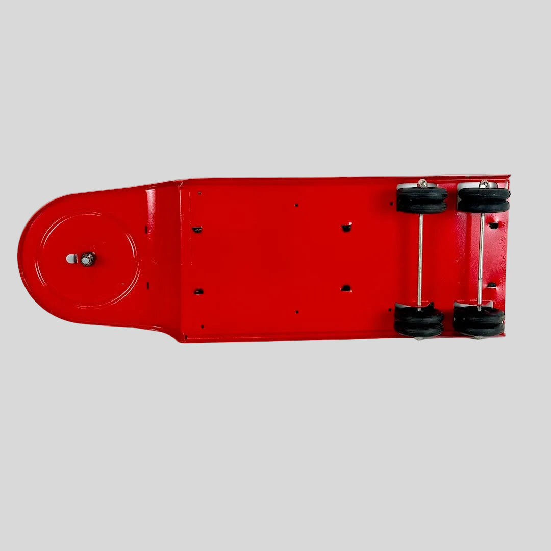 Underside of red toy flatbed trailer against gray background. 