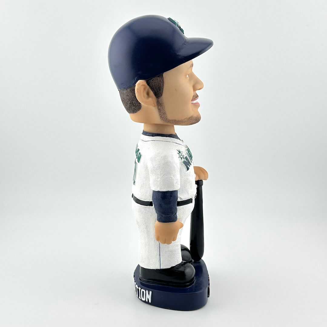 Bobblehead of a baseball player in a white and navy uniform with a bat on a light gray background