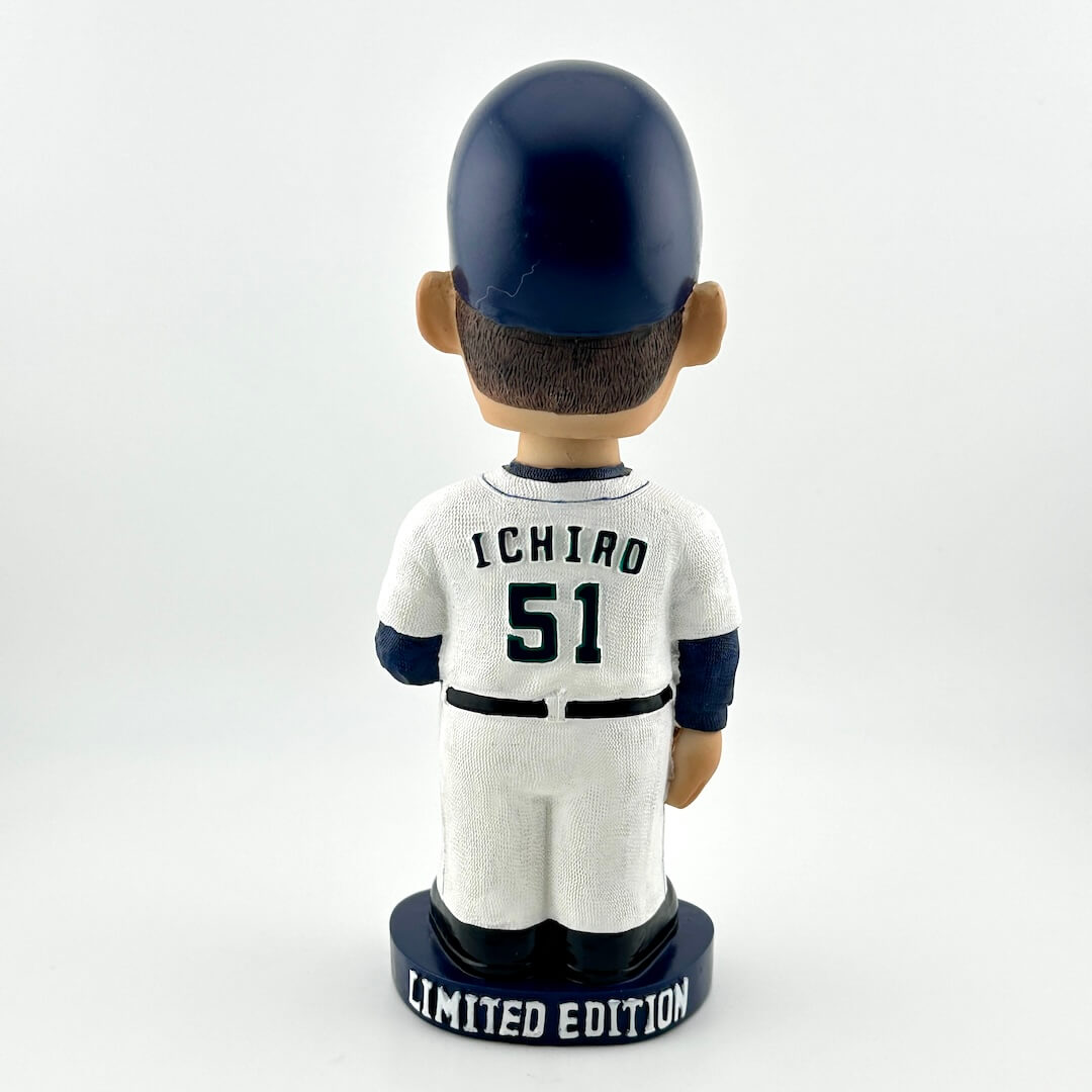 Bobblehead figure of a baseball player in a white uniform with 'Ichiro' and number '51', wearing a navy helmet, on a white background.