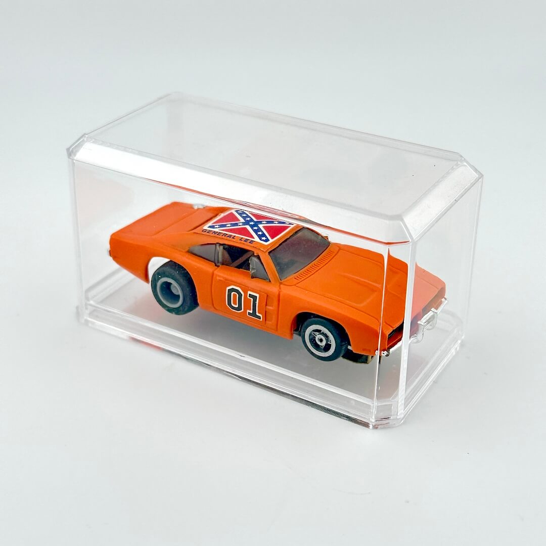 Model car with Confederate flag design in a clear display case on a light gray background