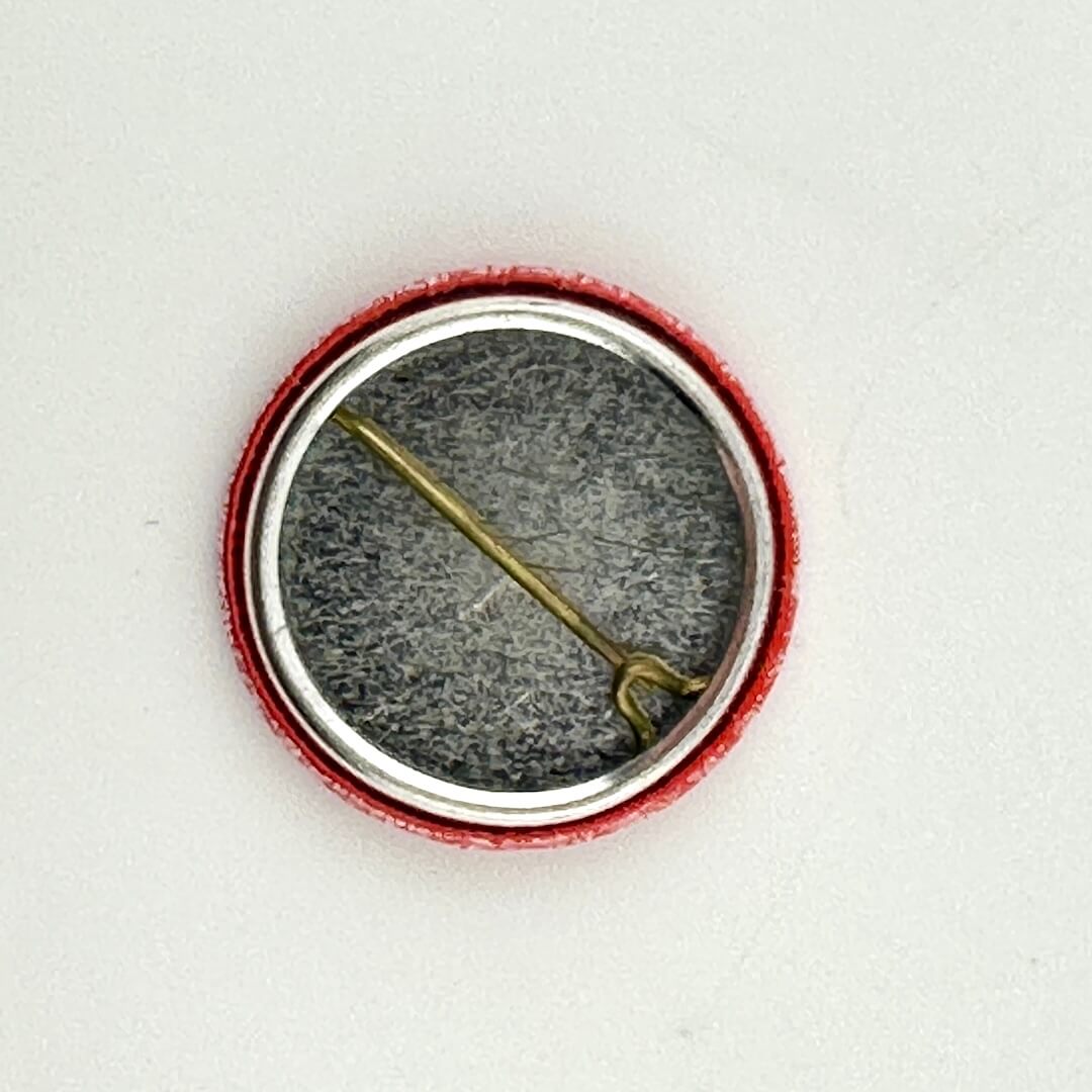 Close-up of a button with a needle on a white background