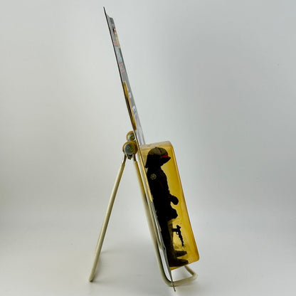 Side view of Star Wars action figure still in packaging on easel against white background.