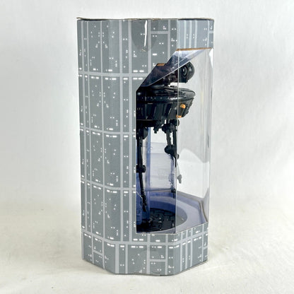 A Star Wars C-3PO droid action figure displayed inside a tall, clear-sided packaging box with a gray and white Star Wars grid pattern.