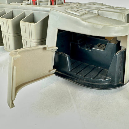 Close up of interior of one compartment of toy spaceship against white background.