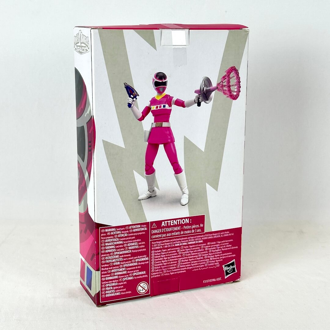 Back of packaging with image of posed action figure above warning labels and product information. 