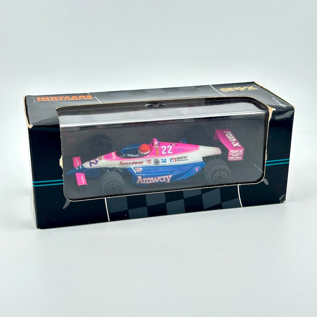 Model race car in a transparent box with a black base on a white background
