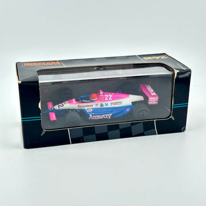 Model race car in a transparent box with a black base on a white background