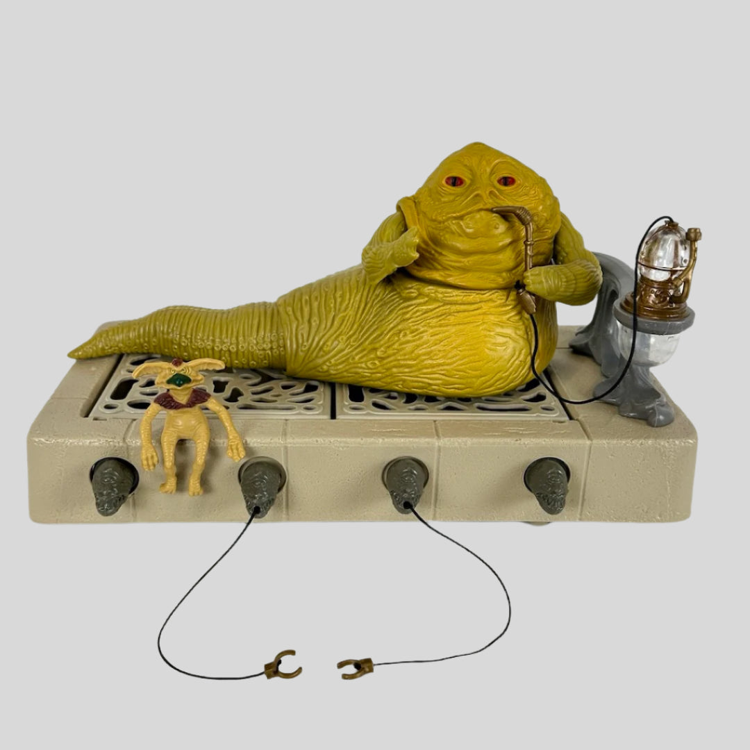 Beige base supporting toy Jabba the Hutt smoking hookah with dome top & bottom, with pet Crumb accessory sitting on edge.