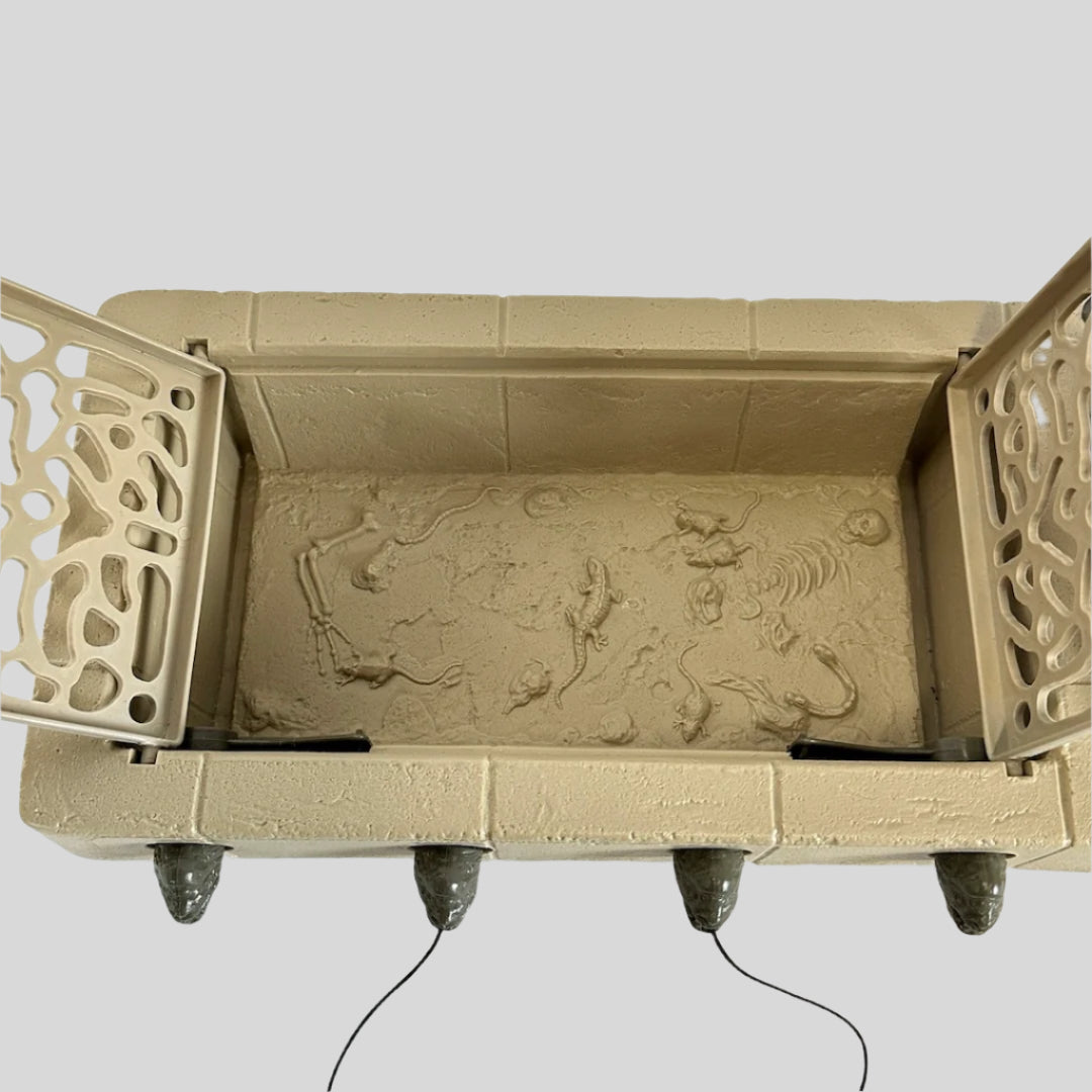 Looking into the trap door in platform base showing embossed skeletal remains and rodents.