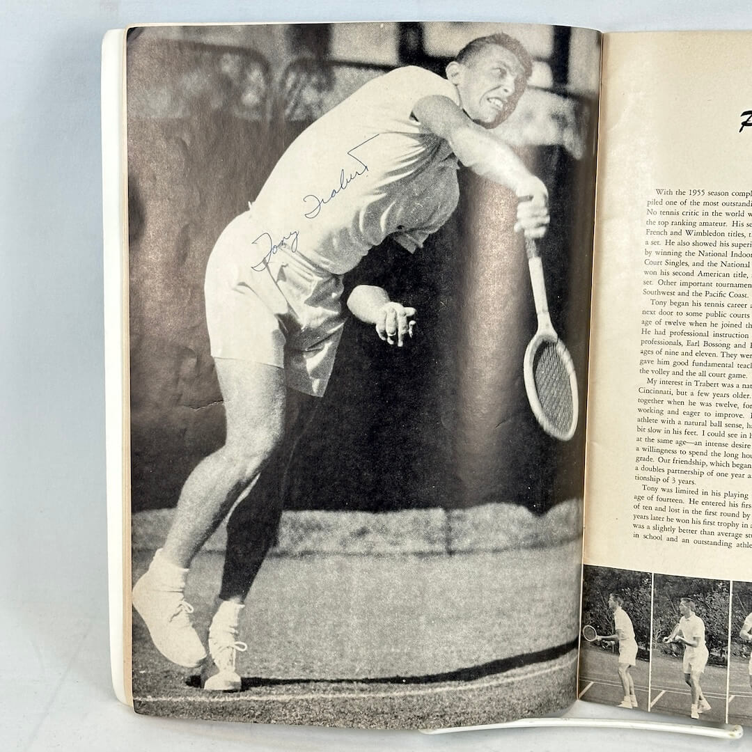 Open book with a signed black and white photograph of a tennis player on the left page and text on the right page.