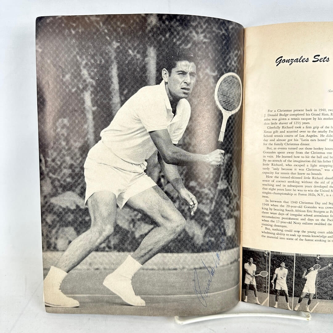 Open book with a signed black and white photo of a tennis player on the left page and text on the right page.