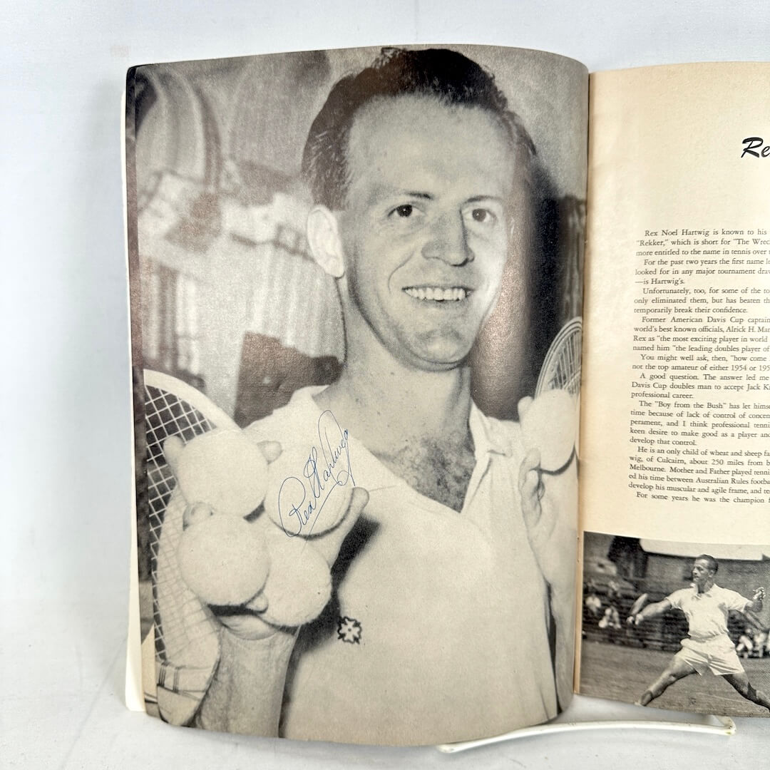 Open book with a signed black and white photo of a man holding a tennis racket, with another photo of a tennis player on the right page.