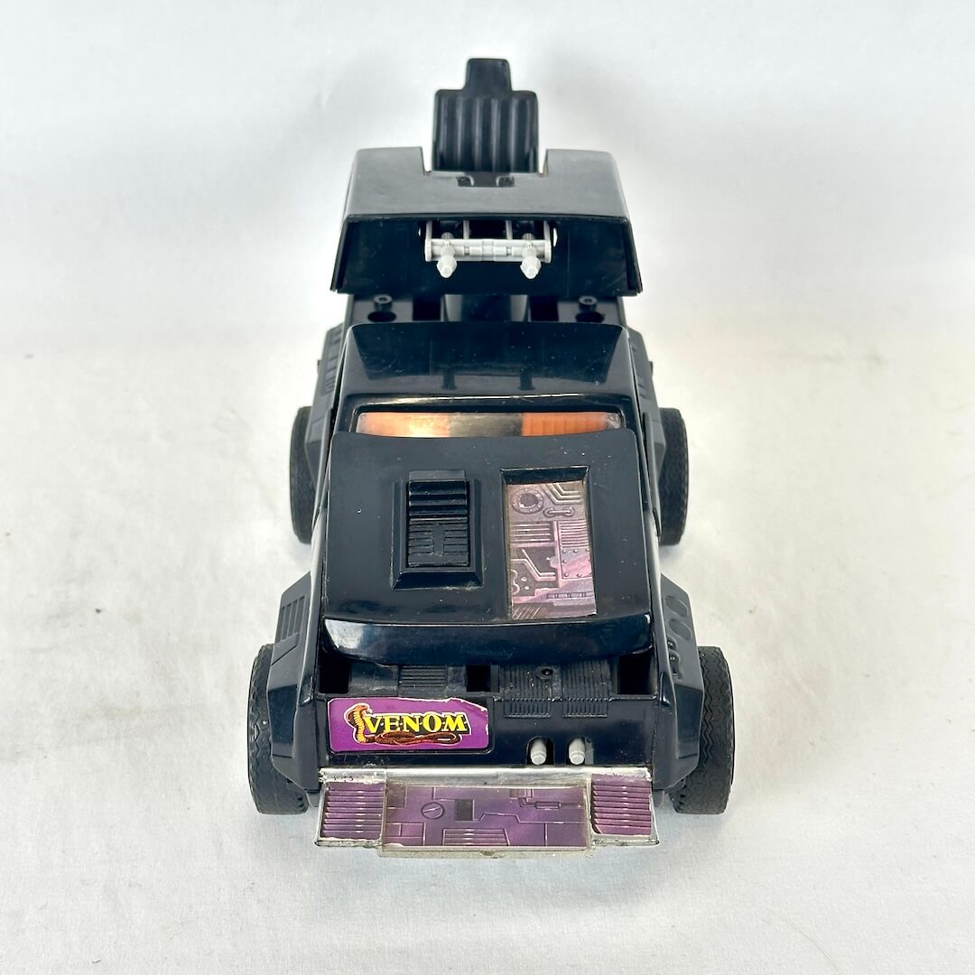 Front view of toy vehicle in with plate over windshield and gun turret in back. 