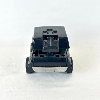 A black plastic toy vehicle, photographed from the rear on a white background.