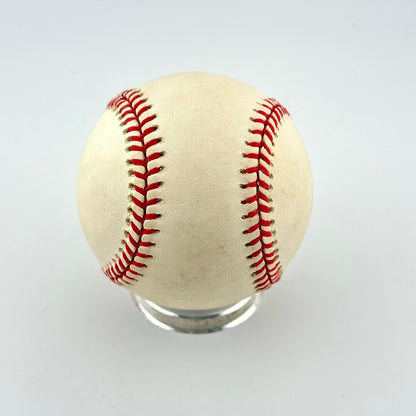 A single vintage baseball with red stitching and a weathered off-white leather surface.