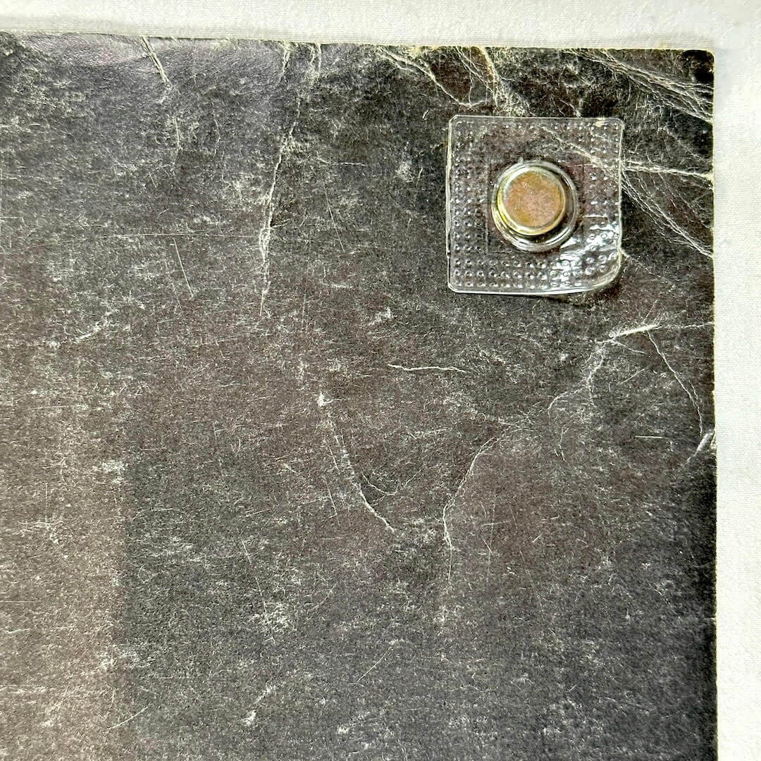 Top left corner with creases and scratches. 