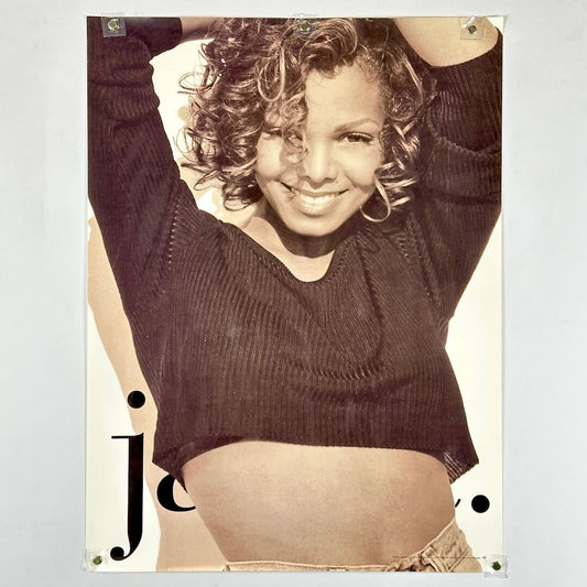 Poster of Janet Jackson wearing a crop top with hands above her head, "J" in bottom left corner.