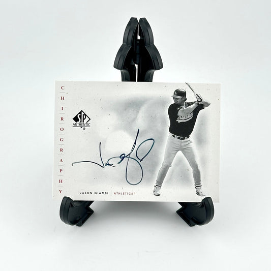 Baseball trading card of a player in action with a signature, held by black card holders on a white background.
