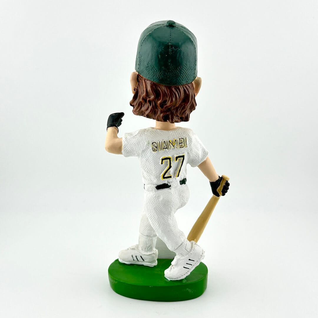 Bobblehead of a baseball player in a white uniform with green cap and bat, on a white background