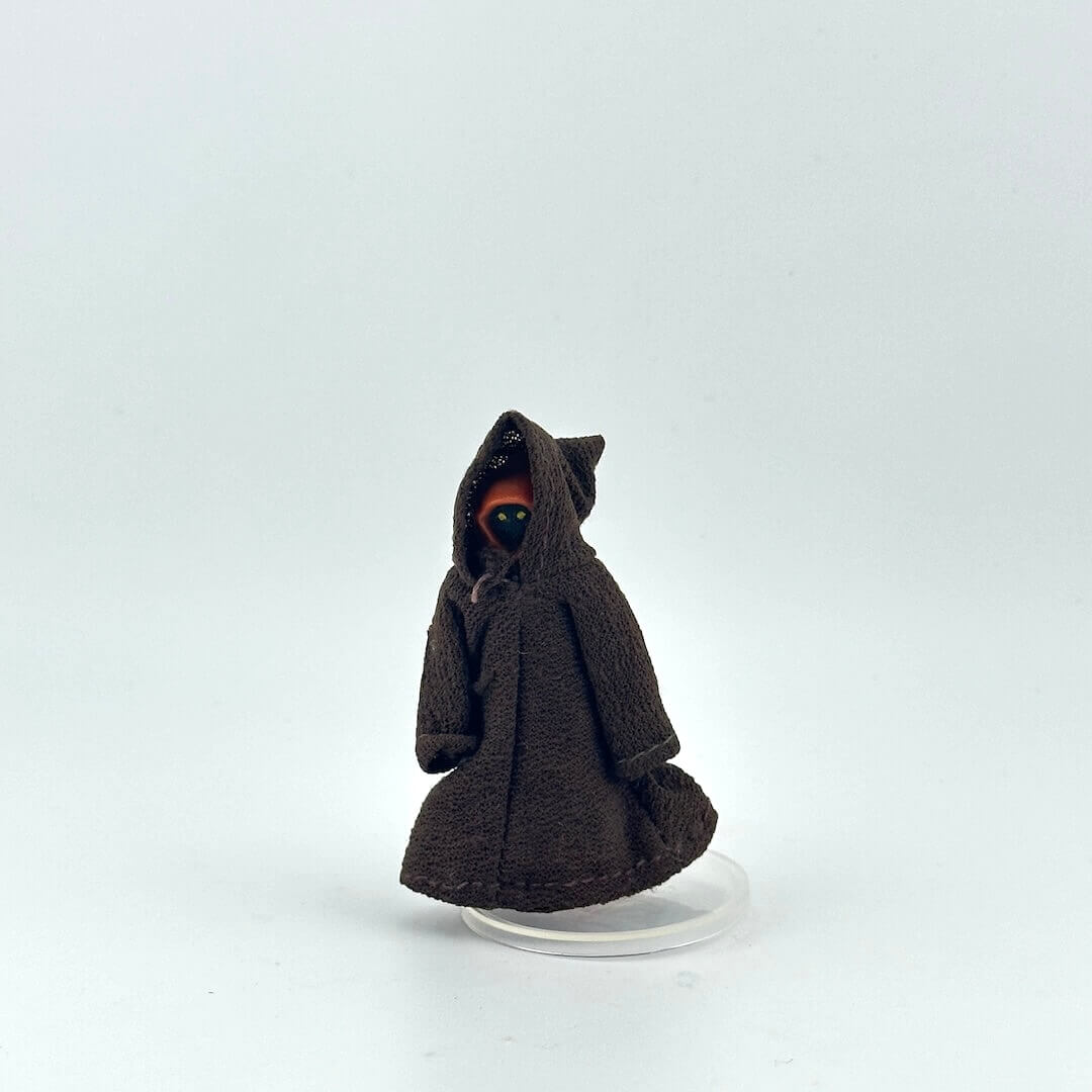 Small figure of a character in a brown robe on a white background