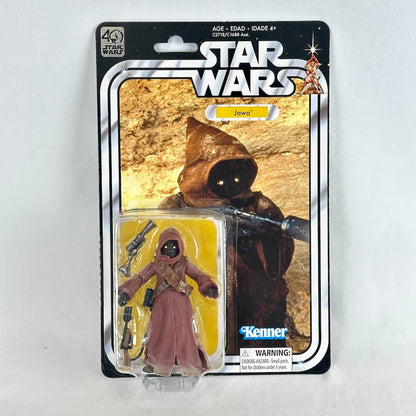 Star Wars action figure in original blister packaging with retro-style card backing, figure in brown robe with accessories. 
