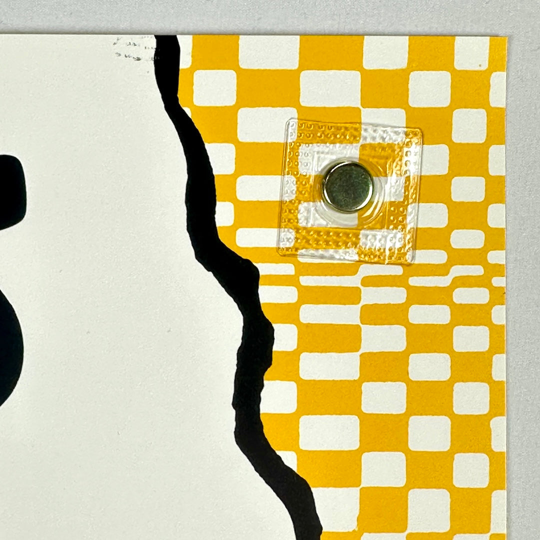 Close-up of a yellow and white checkered pattern with a central button on a gray background