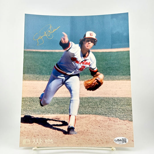 Baseball player in action on a field with a blue sky, wearing a uniform and glove.