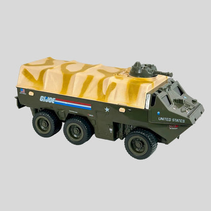 A toy military armored truck model with a tan camouflage-patterned canvas cover, olive green chassis.