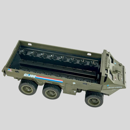A toy military transport truck in olive green with 'GI JOE' and 'UNITED STATES' markings.