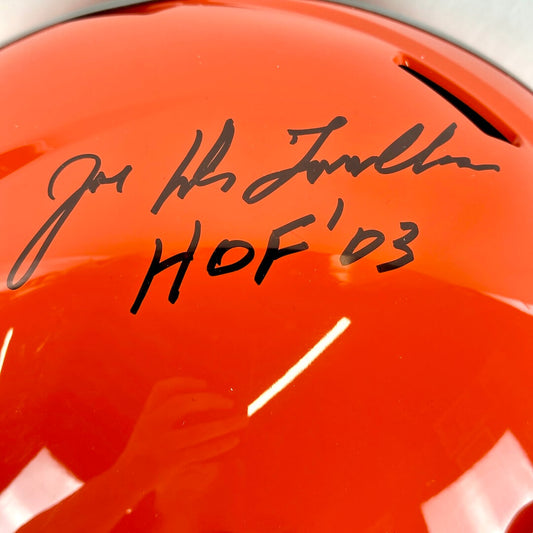 Close-up of a orange helmet with black text and signature
