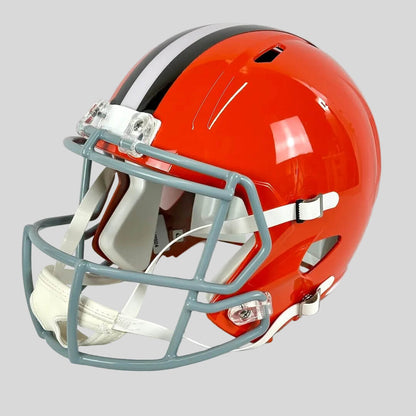 Orange football helmet with a white face mask on a light gray background