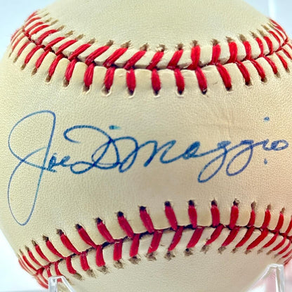 Baseball with red stitching and blue signature on a white background