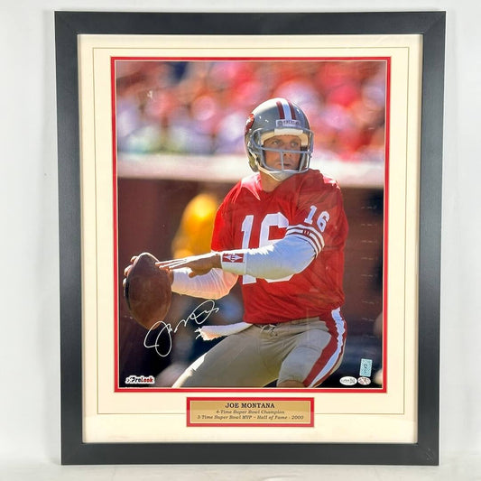A framed, autographed photo of Joe Montana in his San Francisco 49ers red jersey, signed in silver ink.
