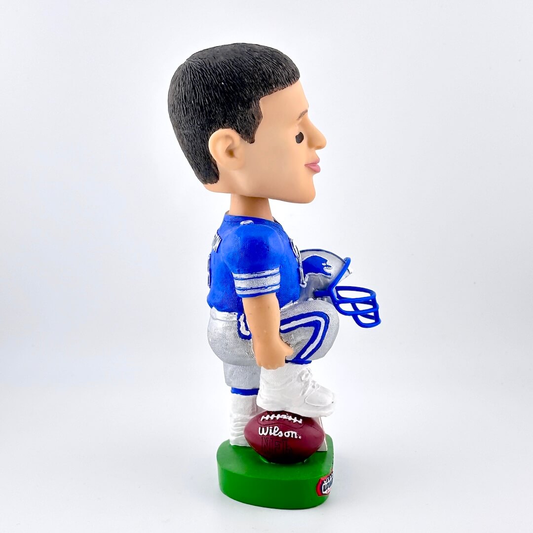 Bobblehead figure of a football player in a blue uniform with a Wilson football on a white background