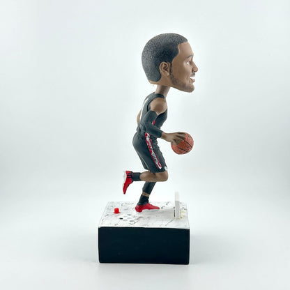 Bobblehead of a basketball player in action on a white background