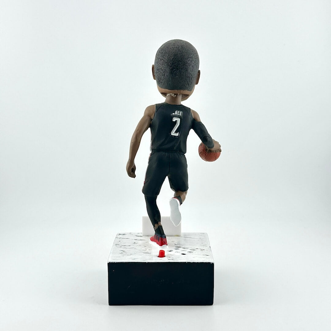 Bobblehead figure of a basketball player in a black jersey with the number 2 on a white background
