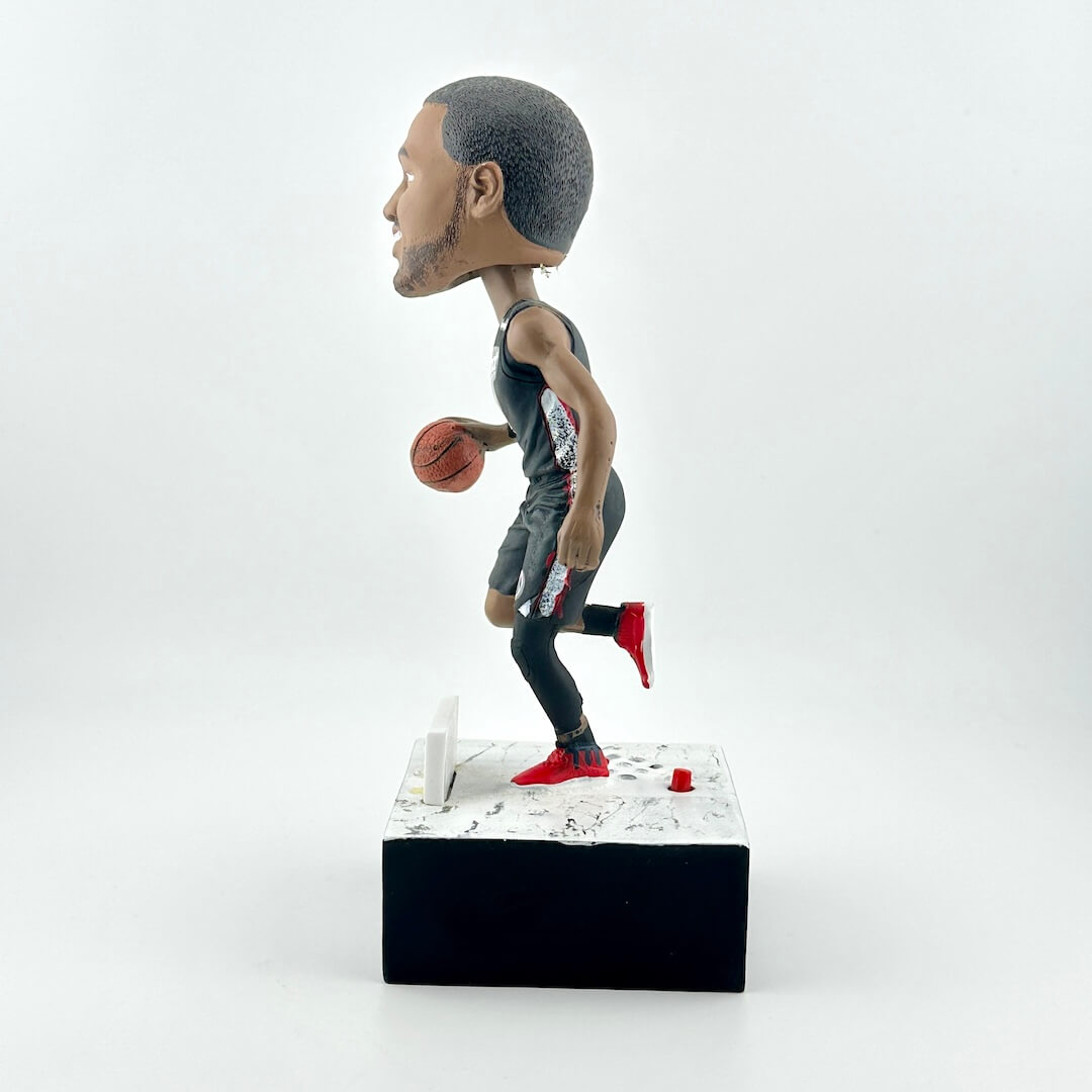 Bobblehead figure of a basketball player holding a ball on a white background