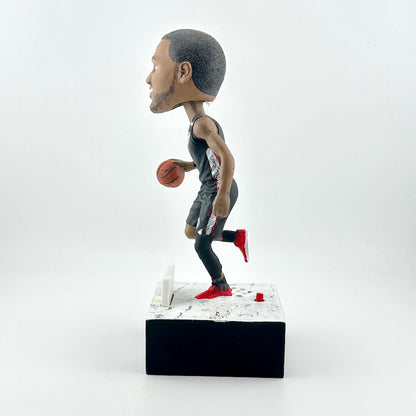 Bobblehead figure of a basketball player holding a ball on a white background